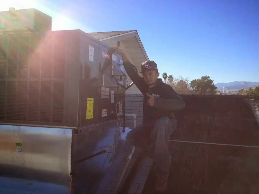 HVAC technician performing Heat Pump Repair on a rooftop unit in Edgewater